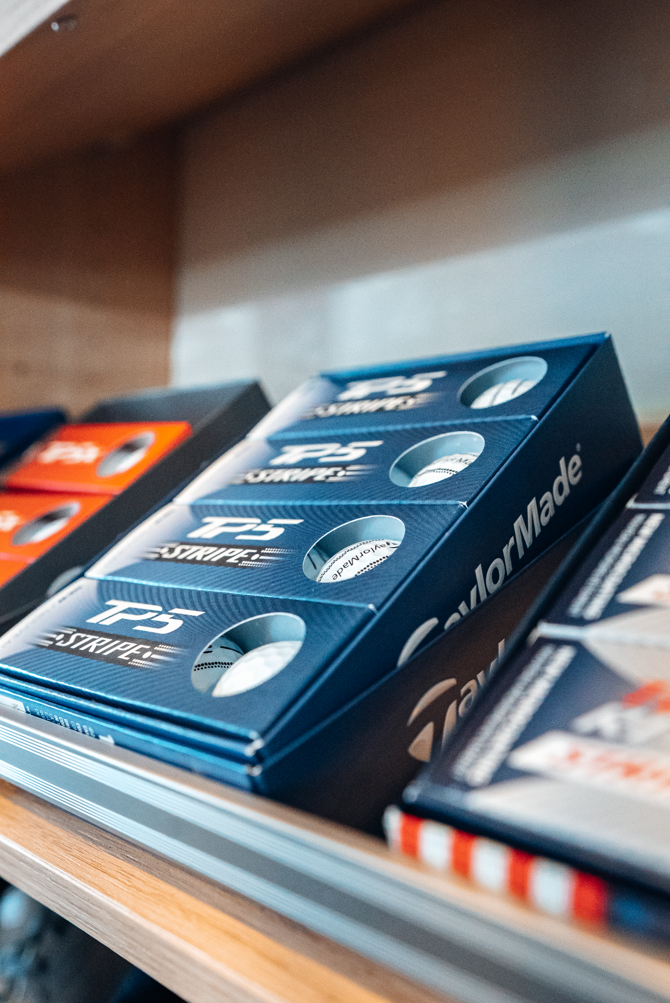 Custom made PS5 controller boxes on a shelf. The boxes are blue and have a circular cutout.